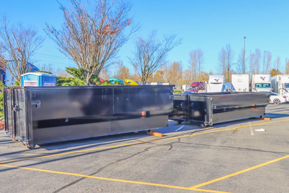 Professional dumpster rental service with roll-off container on residential driveway in West Falls Church